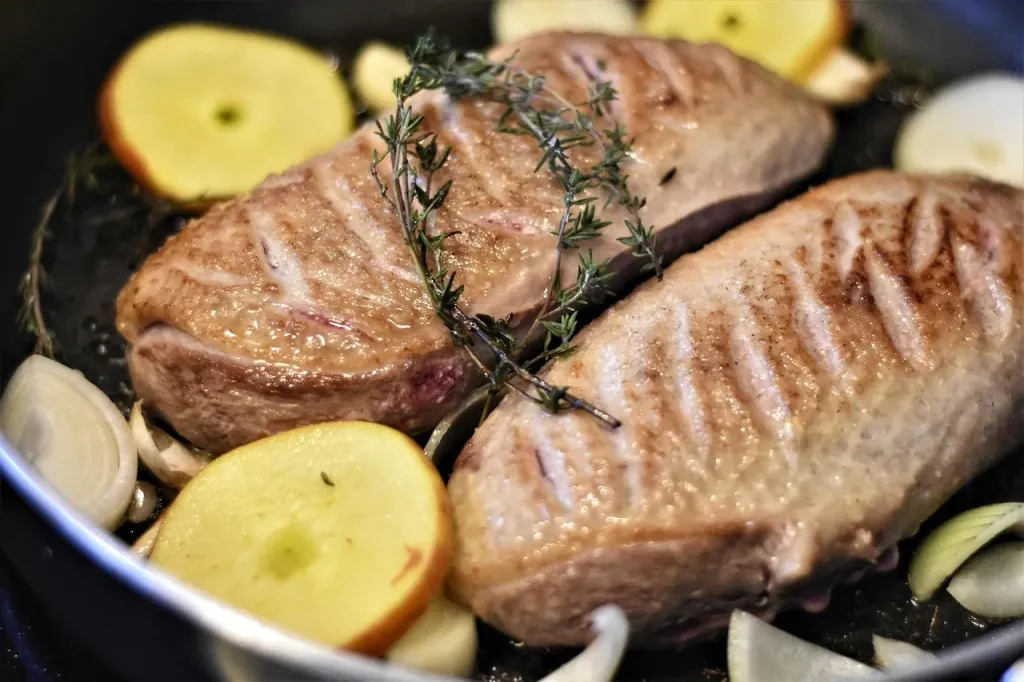 Soczysta pierś z kaczki smażona na patelni z aromatycznymi grzybami.