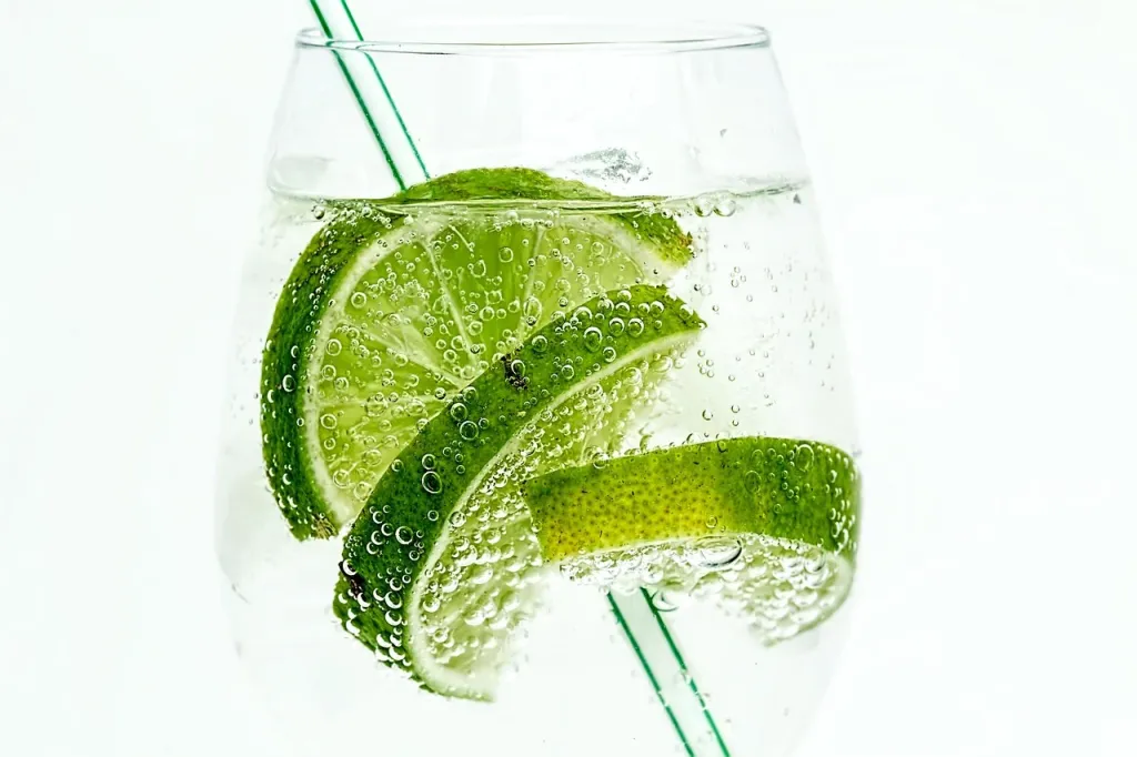 Szklanka orzeźwiającego kwasu chlebowego z plasterkiem limonki, podana jako chłodny napój.